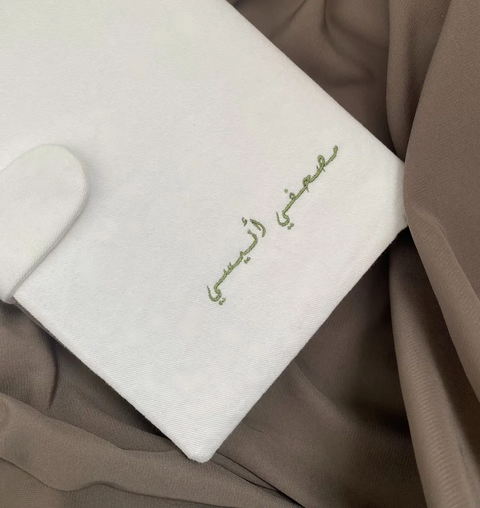 Protège-Coran en coton blanc cassé à rabat arrondi aimanté, « Mushafi anisi » brodé en calligraphie arabe vert olive