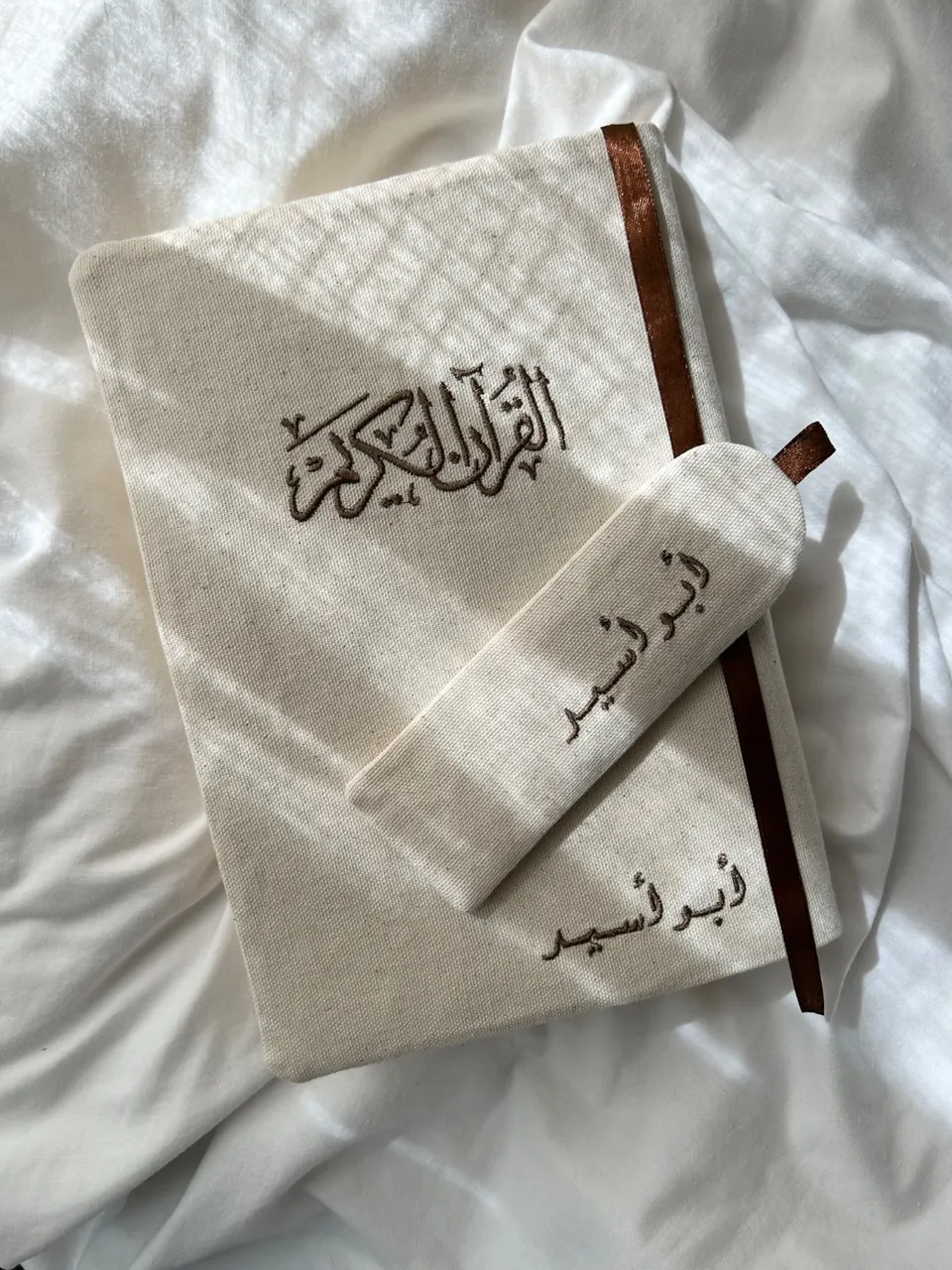 Protège-Coran en coton beige tacheté, calligraphie Coran Karim et prénom arabe brodés marron chocolat, ruban marron et marque-page en tissu assorti