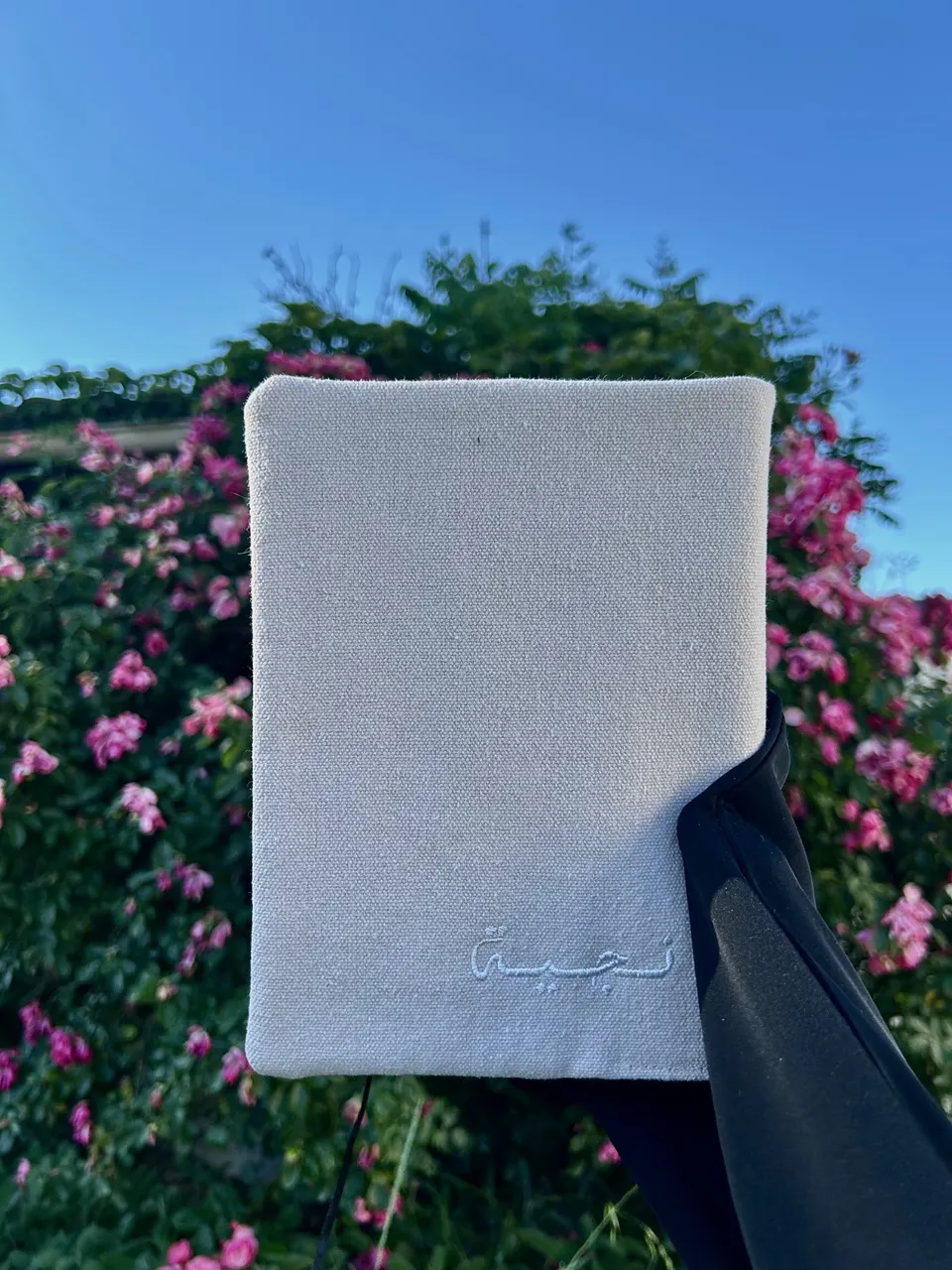 Protège-Coran minimaliste en coton rose pâle, prénom en calligraphie arabe brodé en fil blanc