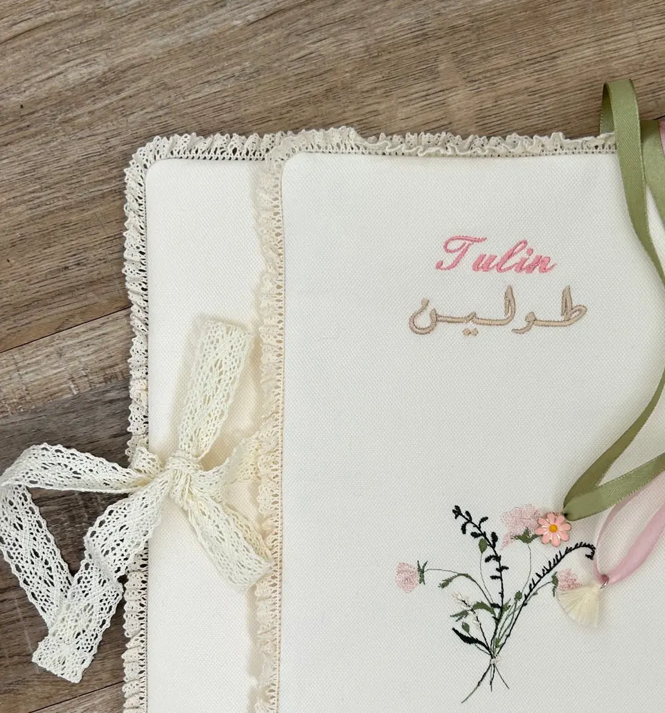 Protège-Coran en coton crème, bouquet de fleurs et prénom brodés rose saumon et miel doré, dentelle macramé crème, nœud macramé crème